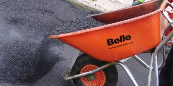 Contractor using the Belle Warrior Wheelbarrow to unload tarmac