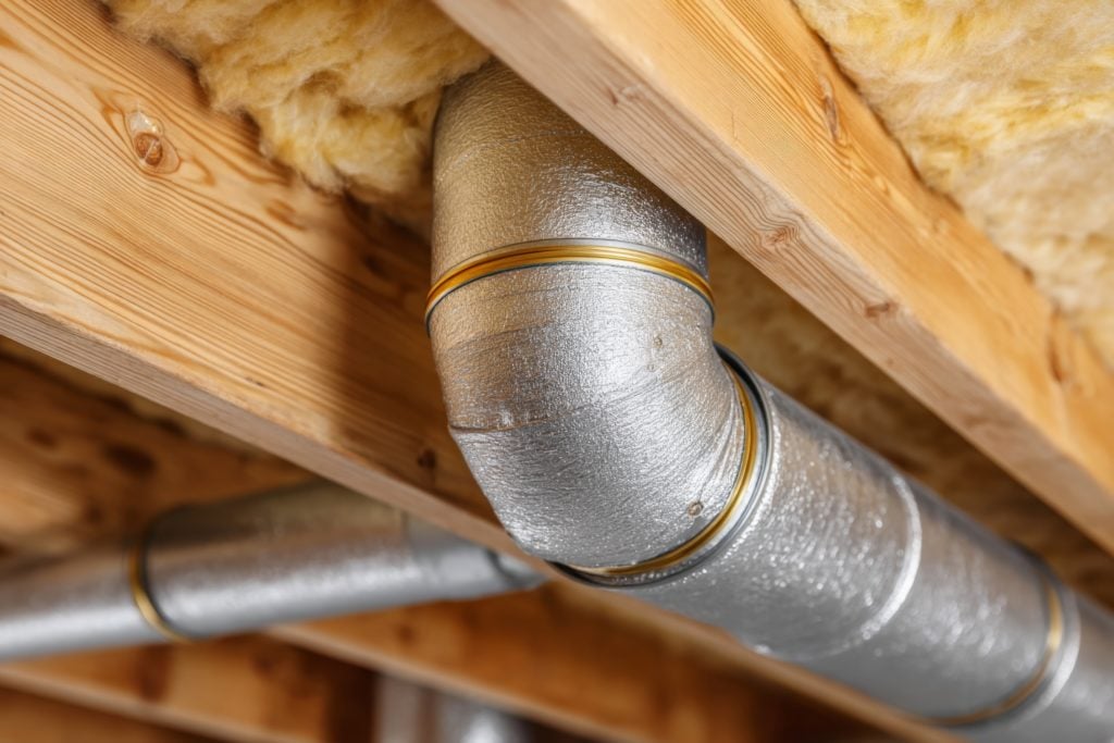 Pipes in attic or wooden ceiling with insulation
