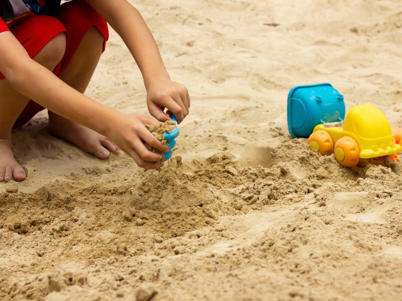 Child playing in sand pit