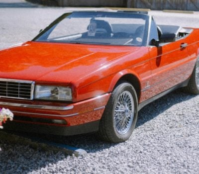 Red convertible car on gravel driveway