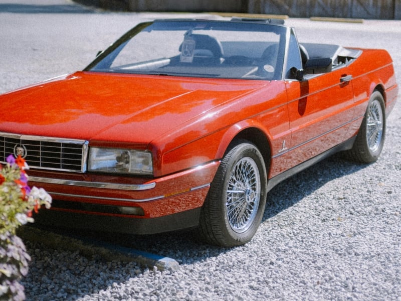 Red convertible car on gravel driveway