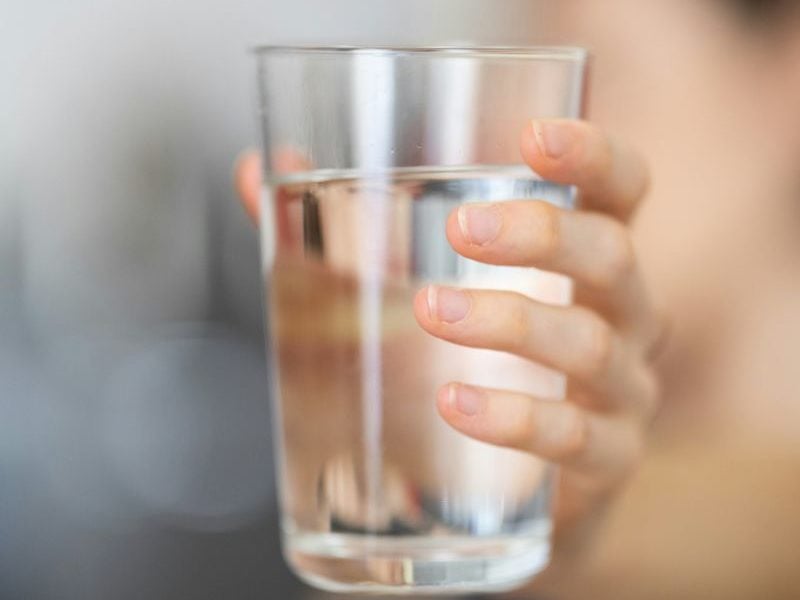 person holding a glass of water