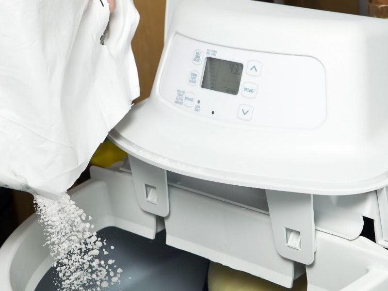 pouring salt into water softener system