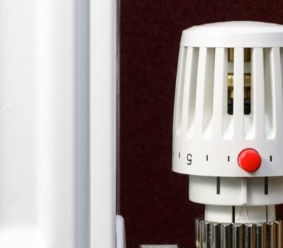trv radiator valve next to a radiator infront of a brown wall