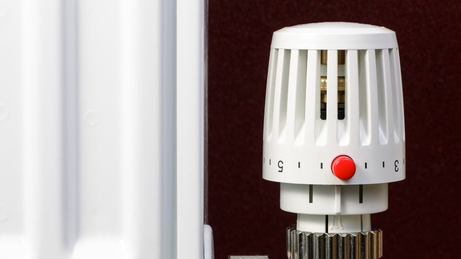 trv radiator valve next to a radiator infront of a brown wall