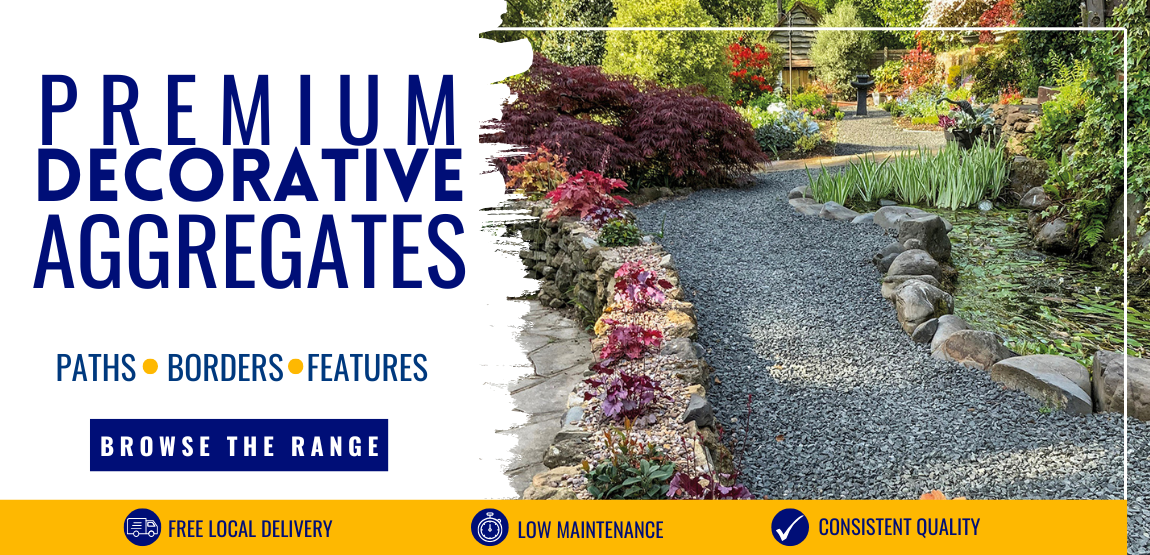 A grey gravel driveway leading to a house, with traditional rockery either side as a retaining edge, next to a small pond