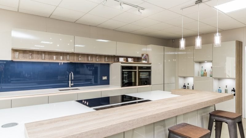 Rotpunkt Modern high gloss white kitchen with blue glass backsplash