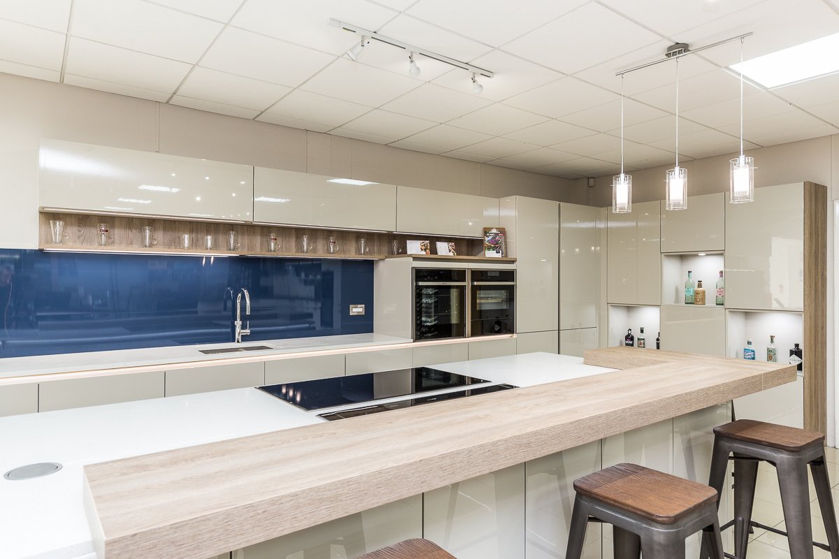 Rotpunkt Modern high gloss white kitchen with blue glass backsplash