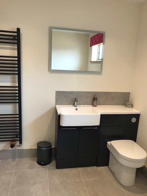 Modern bathoom with built-in vanity unit and WC with conceled cistern