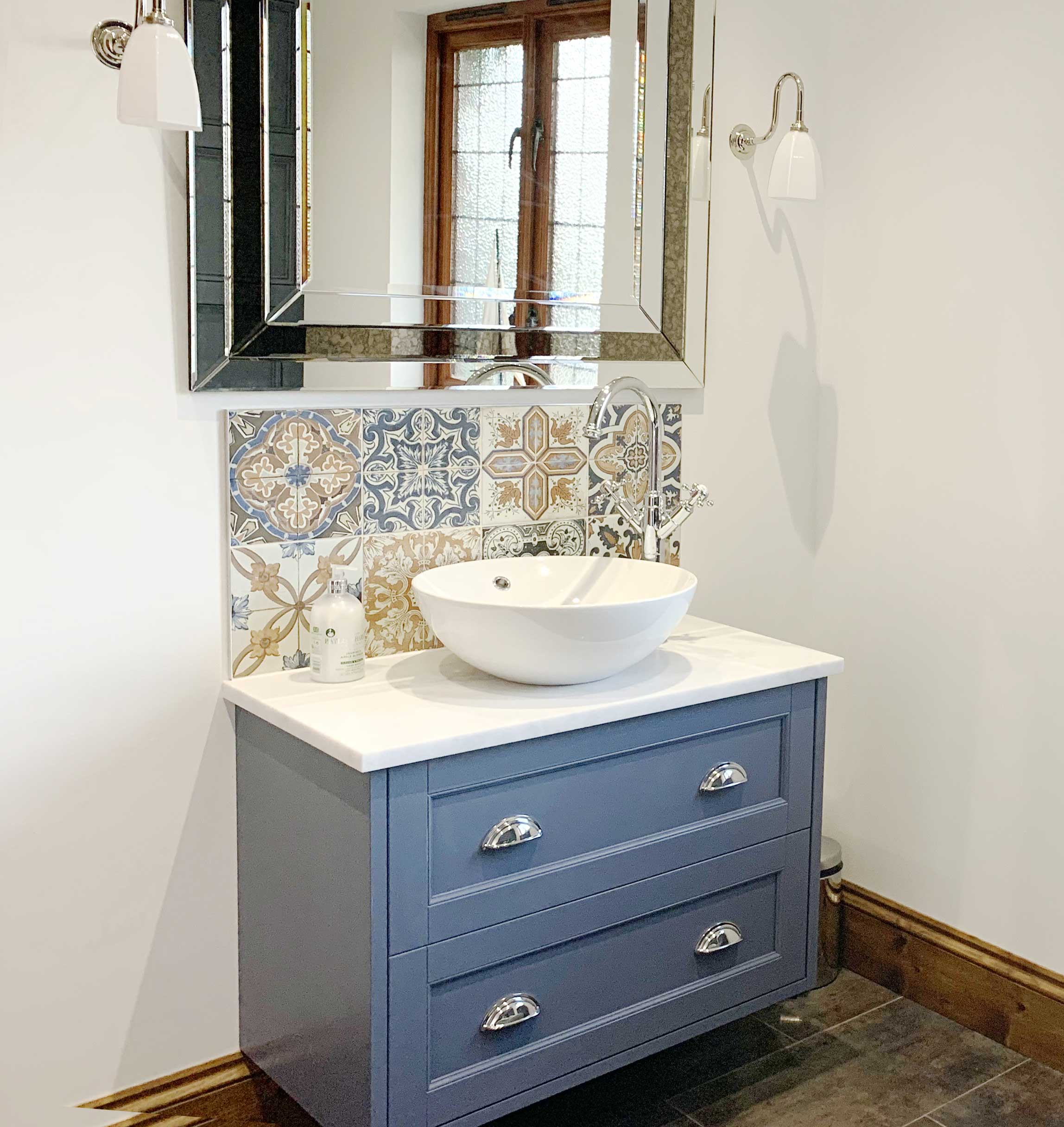 Traditional vanity unit paired with a modern basin and statement tiles make this bathroom