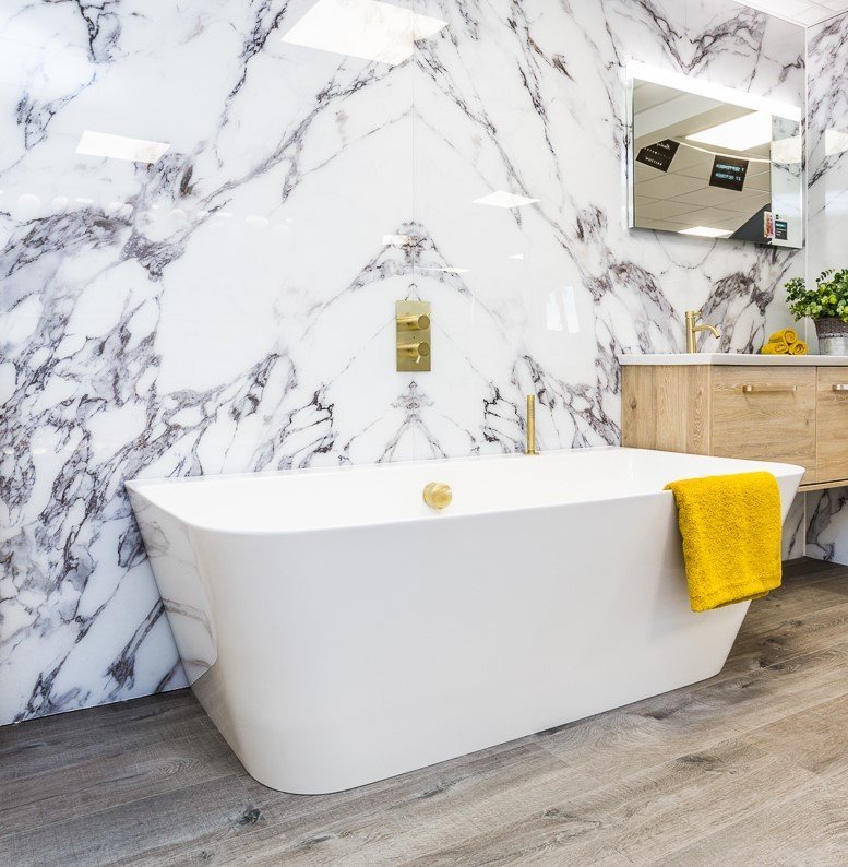 Bathroom Ideas - bold marble wall with freestanding bath and gold fixtures