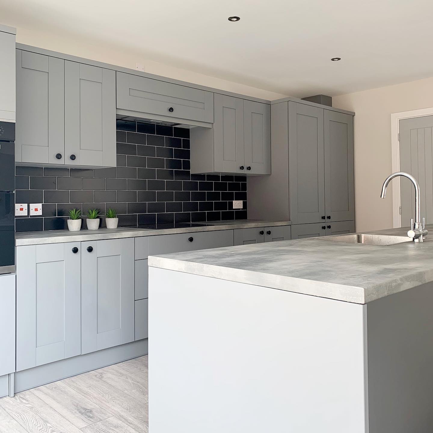 Charworth Homes - Grey Kitchen with statement tiles in black