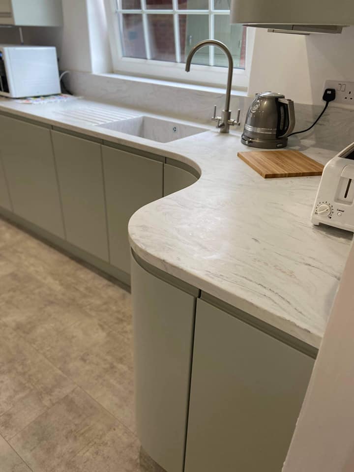 Curved worktop and kitchen cabinets in pale green
