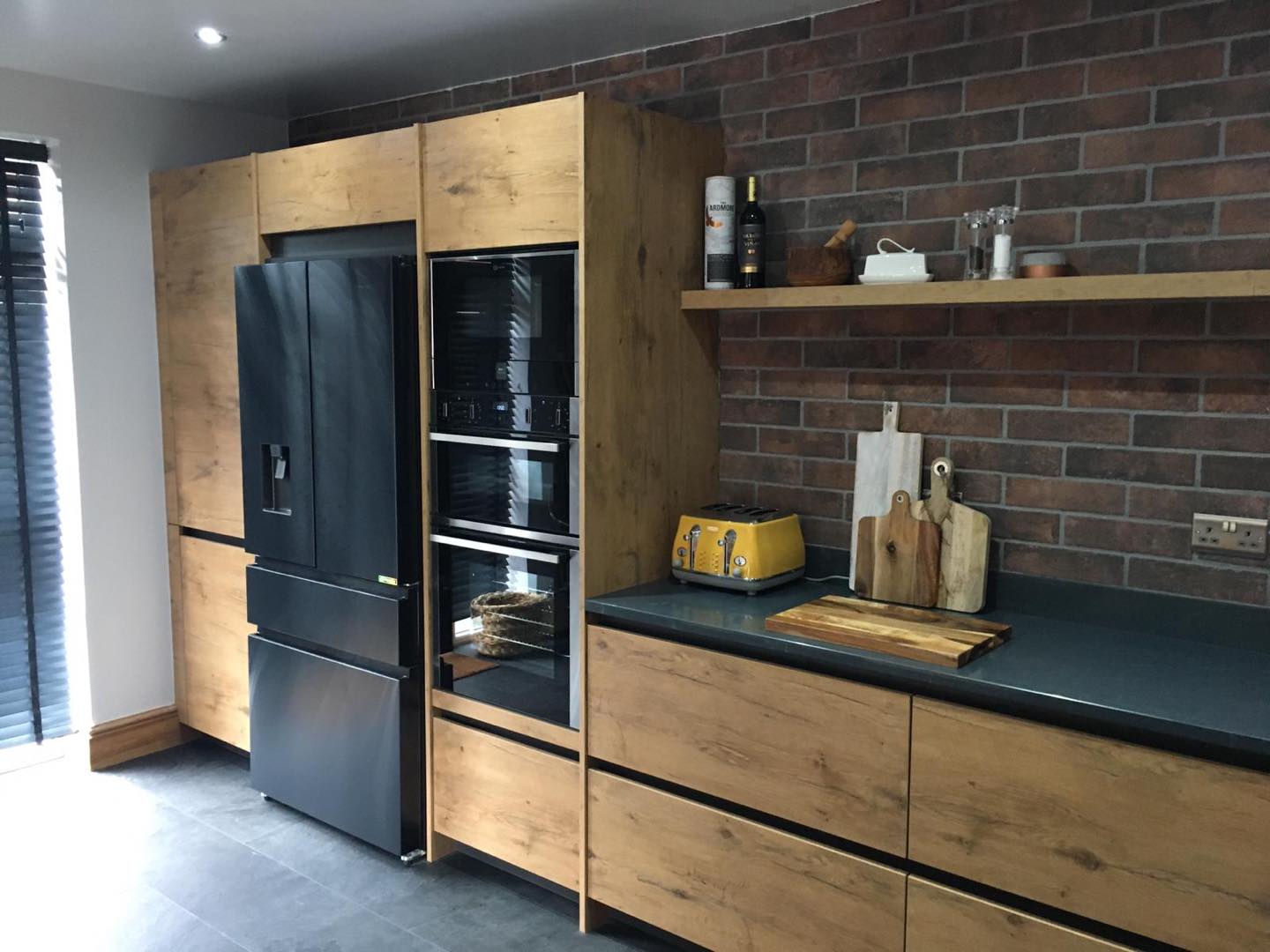 Old Wild Oak Kitchen Cabinets from Rotpunkt with Black Countertops