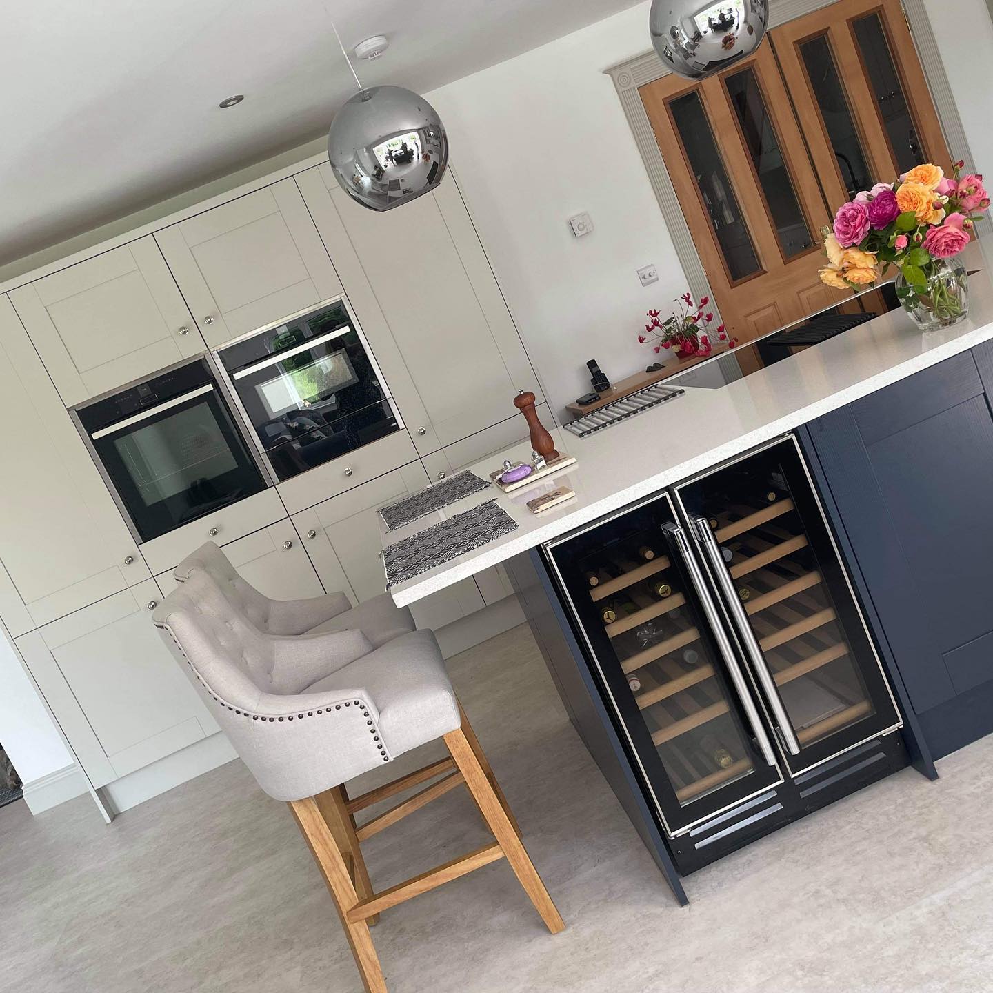 Two tone blue and white kitchen in shaker style with breakfast bar and integrated wine cooler, plus double NEFF ovens at comfort height